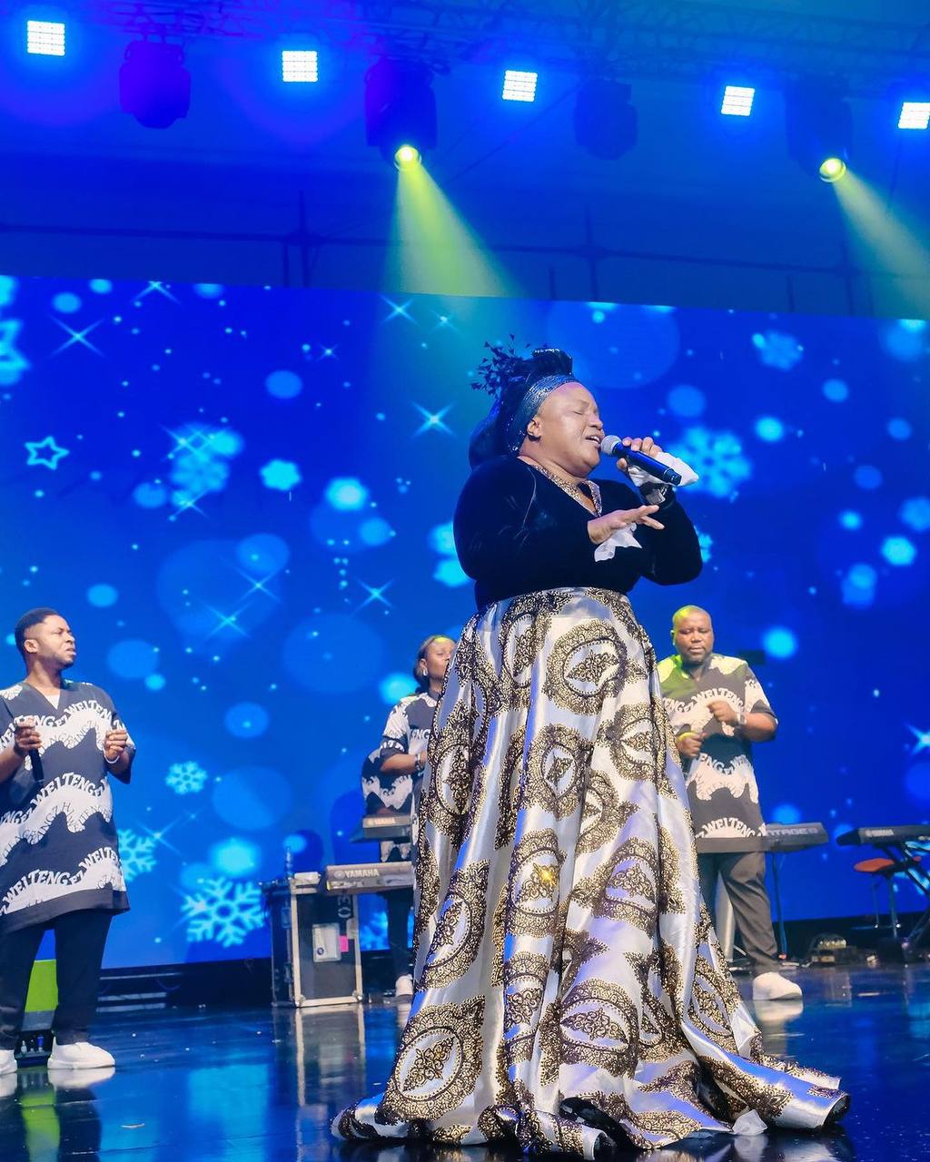 Vocalist performing in front of a blue LED visual backdrop
